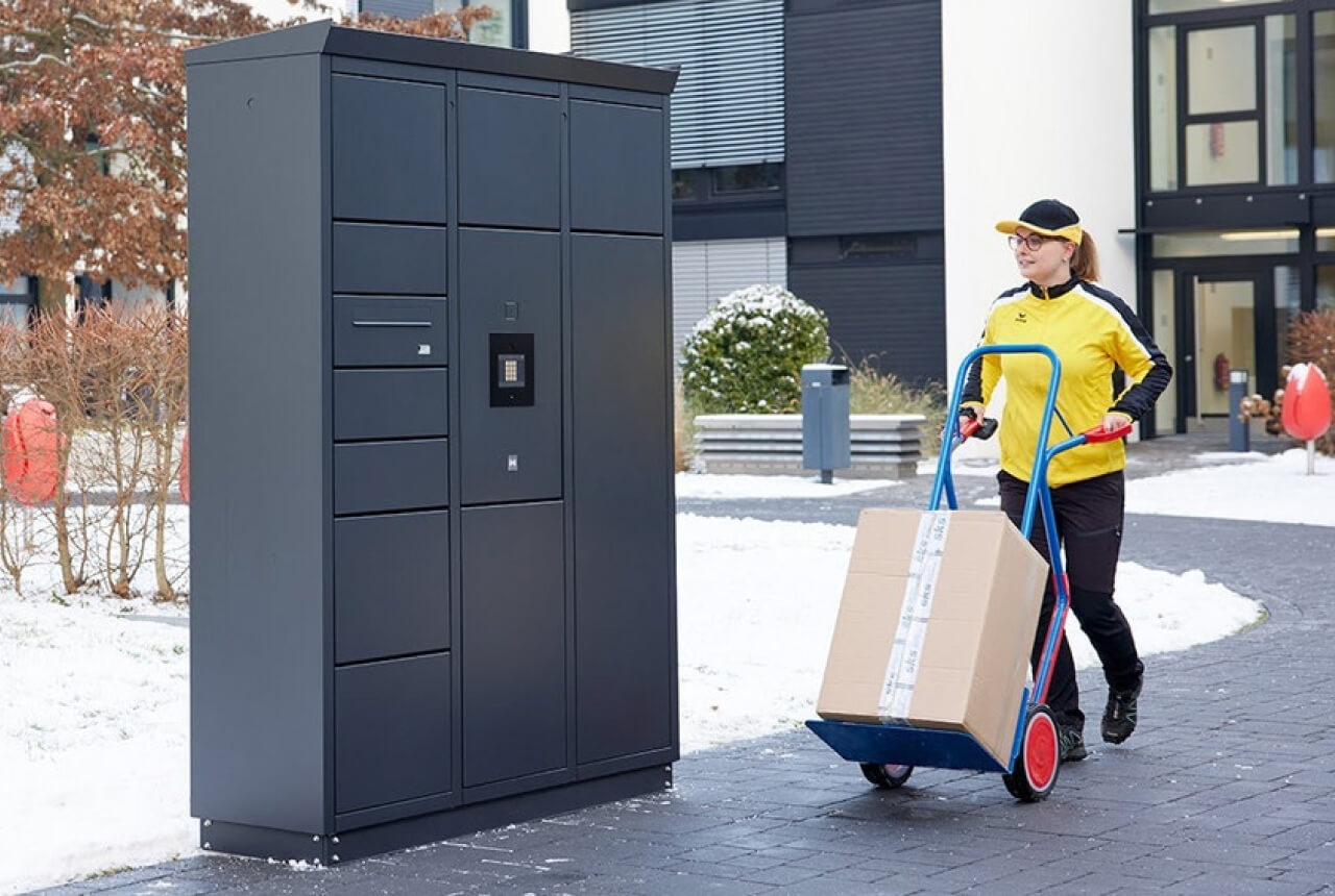 Eine Paketfahrerin liefert neue Pakete für die hauseigene Packstation